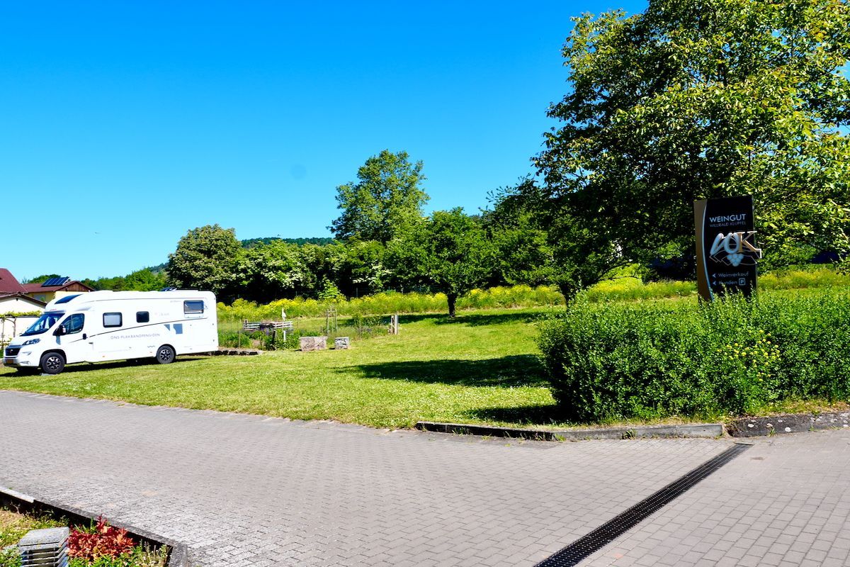 Weingut Willibald Klüpfel Een camper staat geparkeerd in een grasveld naast de weg.