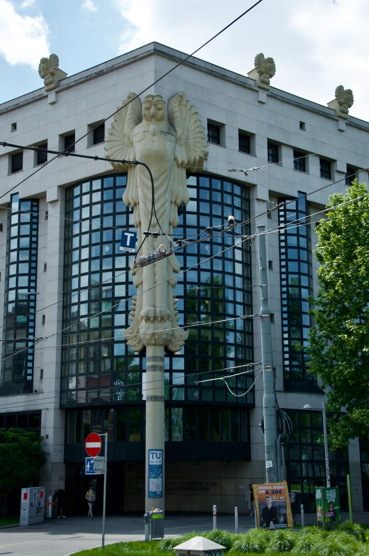 TU Wien Bibliothek - Hauptbibliothek Een groot gebouw met een standbeeld van een engel ervoor