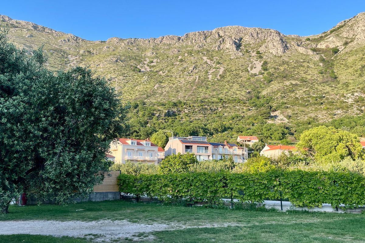 Uitzicht Een veld met huizen op de achtergrond en bergen op de achtergrond.