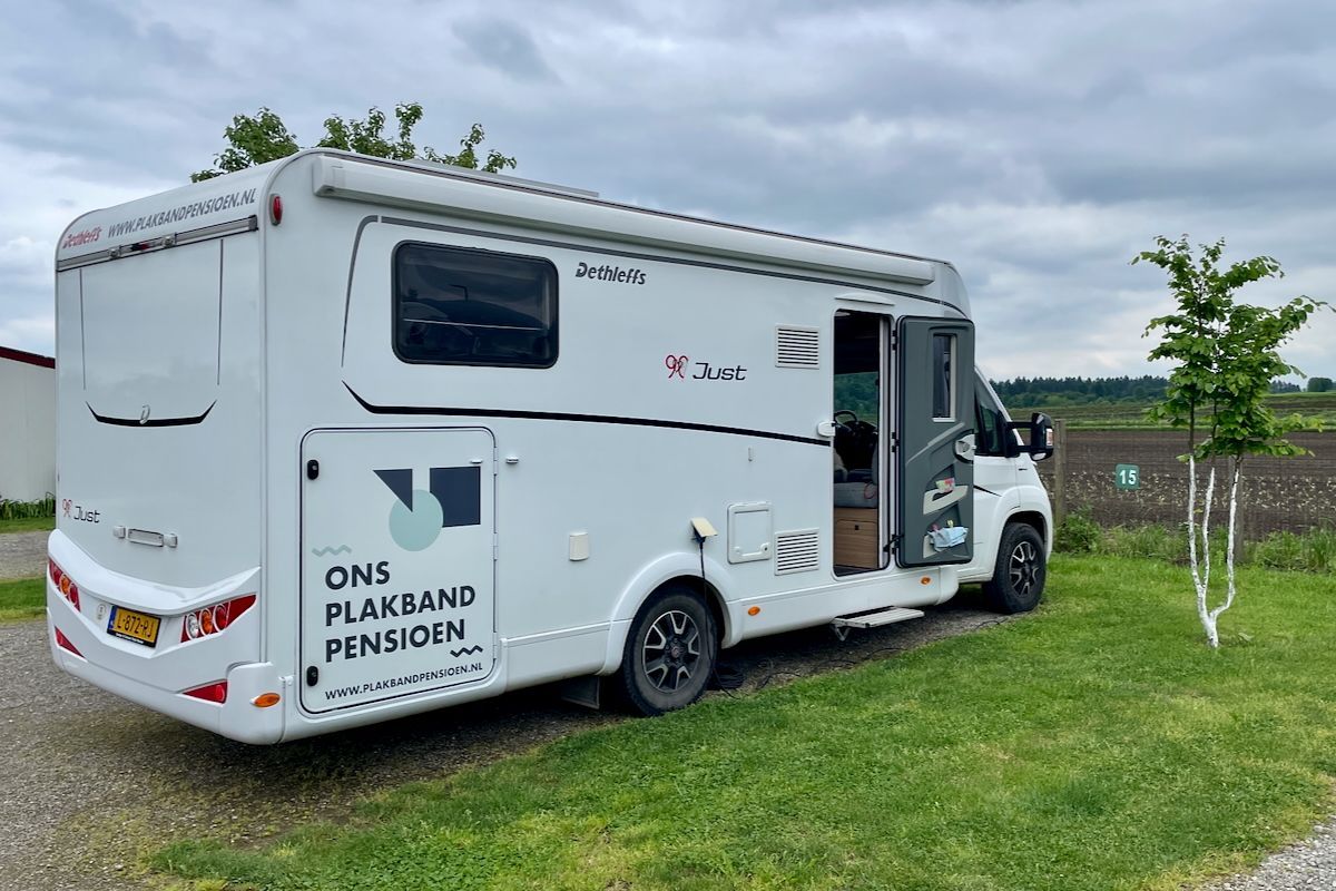 Ons huis in Kroatië Een witte camper staat geparkeerd in een grasveld.
