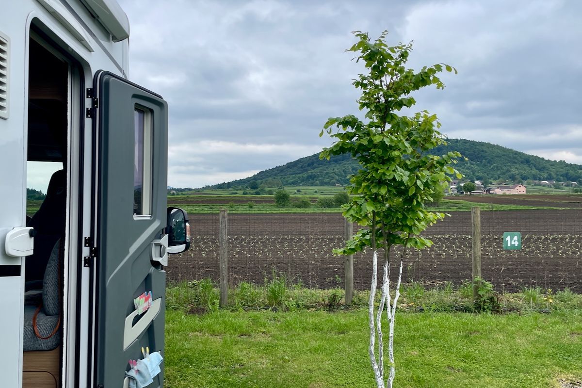 Een berg van een uitzicht Een camper staat geparkeerd in een grasveld met een berg op de achtergrond.