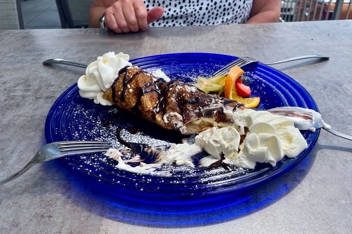 Pannenkoek met vanille-ijs Een blauw bord met daarop een dessert en slagroom.