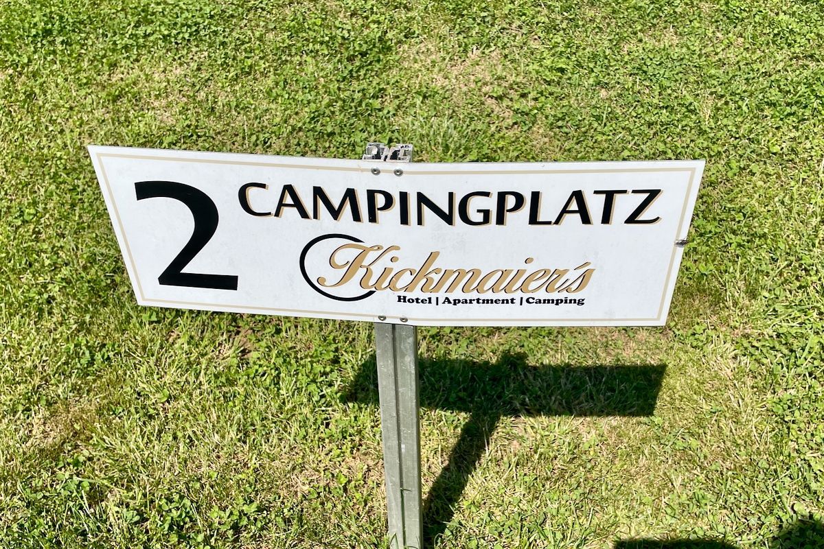 Campingplatz Kickmaier's Een bord met de tekst campingplatz kickmates staat bovenop een weelderig groen veld.