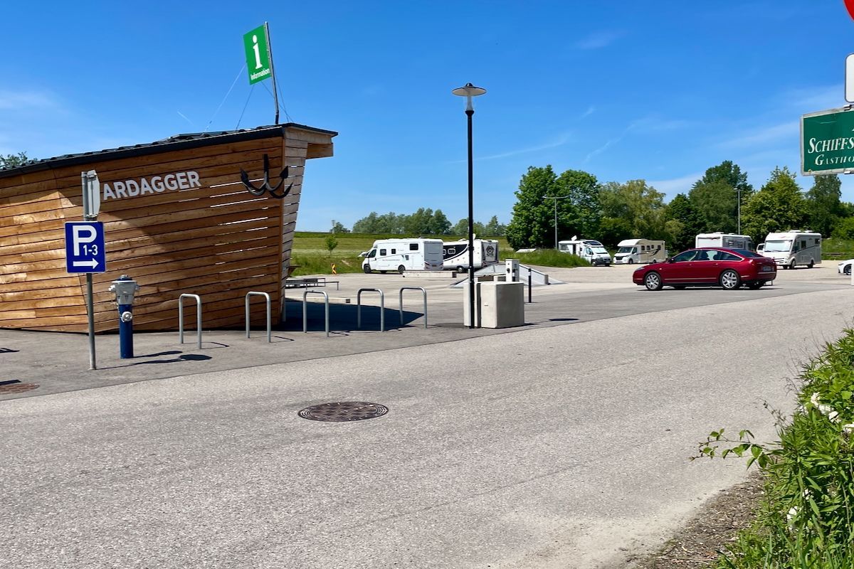 Parkplatz Donauwelle Een rode auto staat geparkeerd voor een parkeerplaats