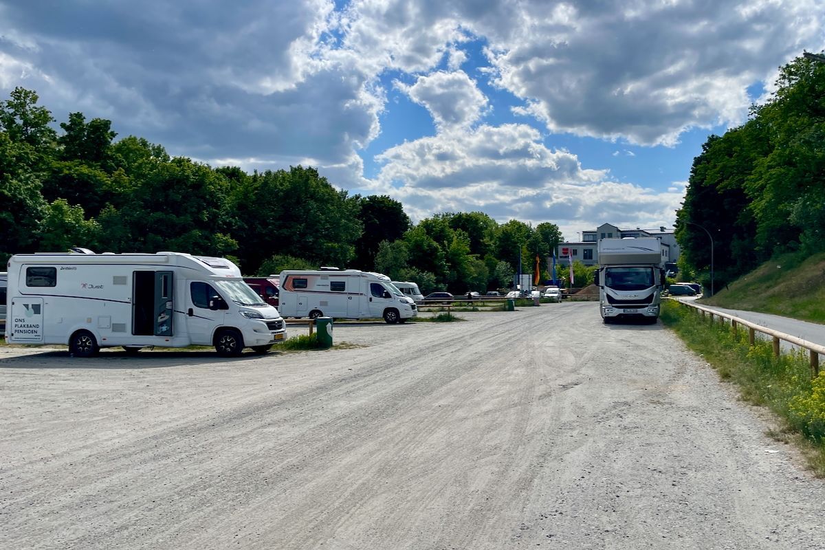Wohnmobilstellplatz am Winterhafen N Een rij campers staat geparkeerd langs een onverharde weg.
