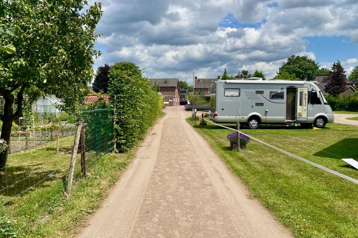 Richting in- uitgang Een camper staat geparkeerd langs een onverharde weg