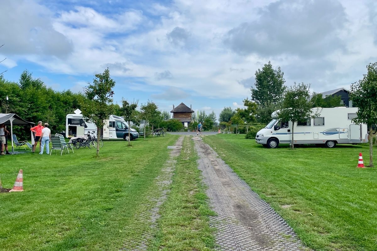 Een groep campers staat geparkeerd in een grasveld.