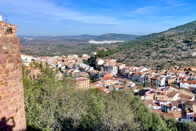 Stadje gelegen in een vallei, gezien vanaf een stenen bouwwerk op een zonnige dag.