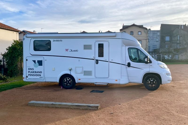 Wit recreatievoertuig geparkeerd op grind.