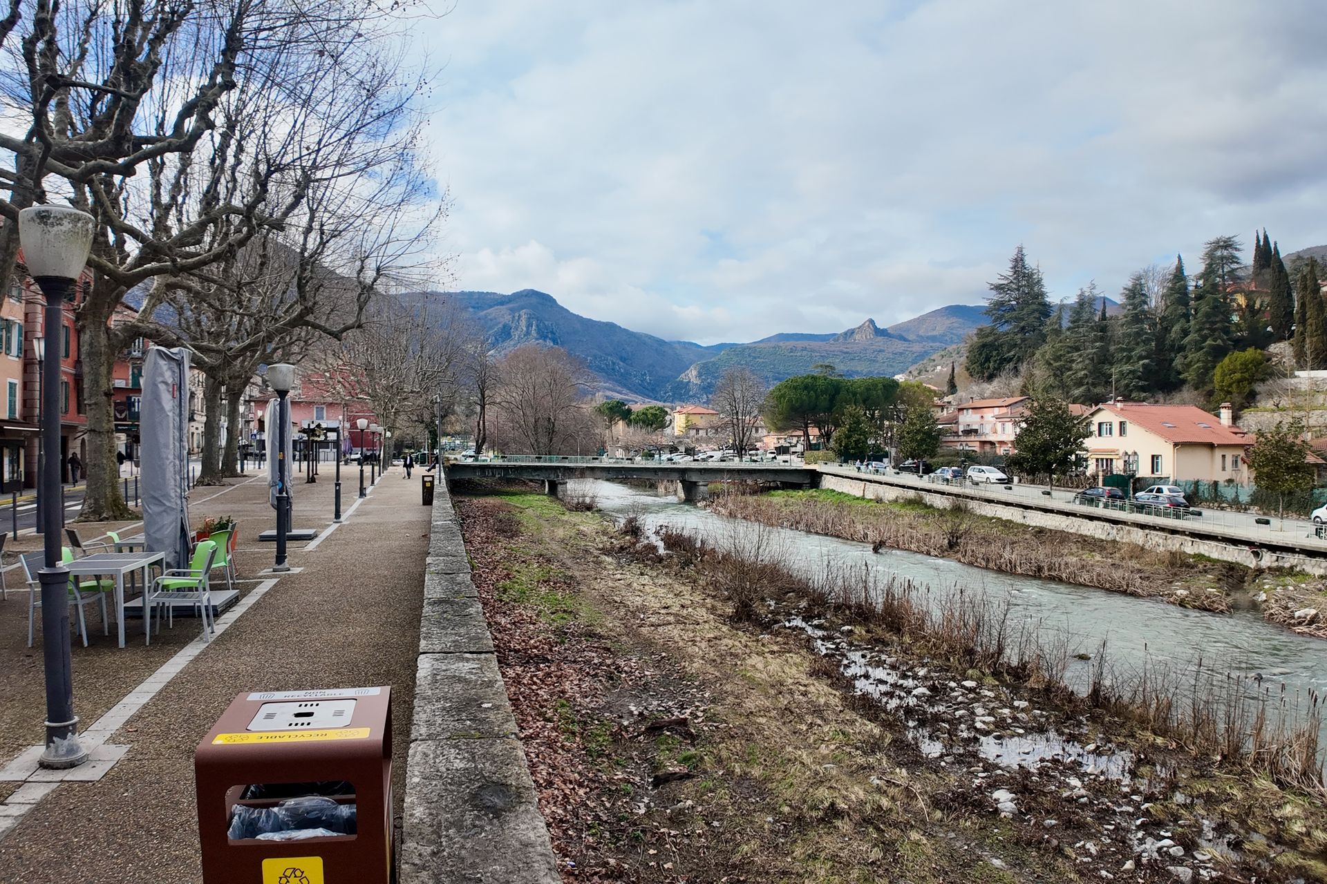 Een schilderachtig uitzicht op een rivier die door een stad stroomt, met bergen op de achtergrond.