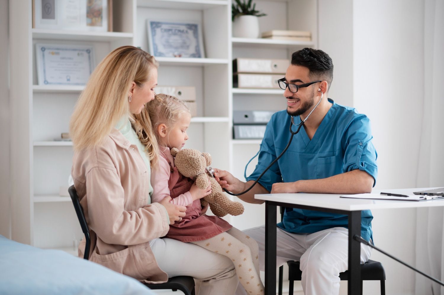 Doctor examining a child while a parent sits nearby in a bright clinic office