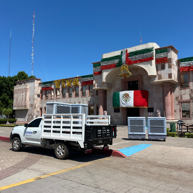 Un camión blanco está estacionado frente al palacio municipal de cajeme y a un lado dos aerocoolers portátiles.