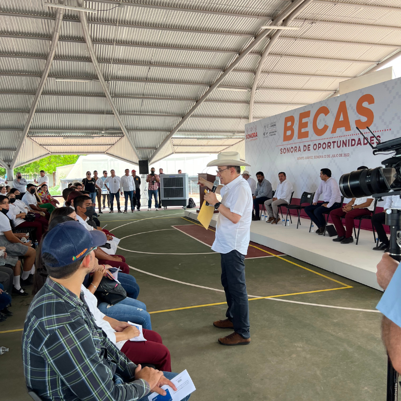 El gobernador de Sonora Alfonso Durazo se encuentra frente a un cartel que dice 