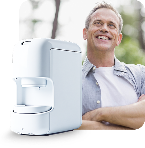 White appliance next to a smiling man outside, arms crossed.