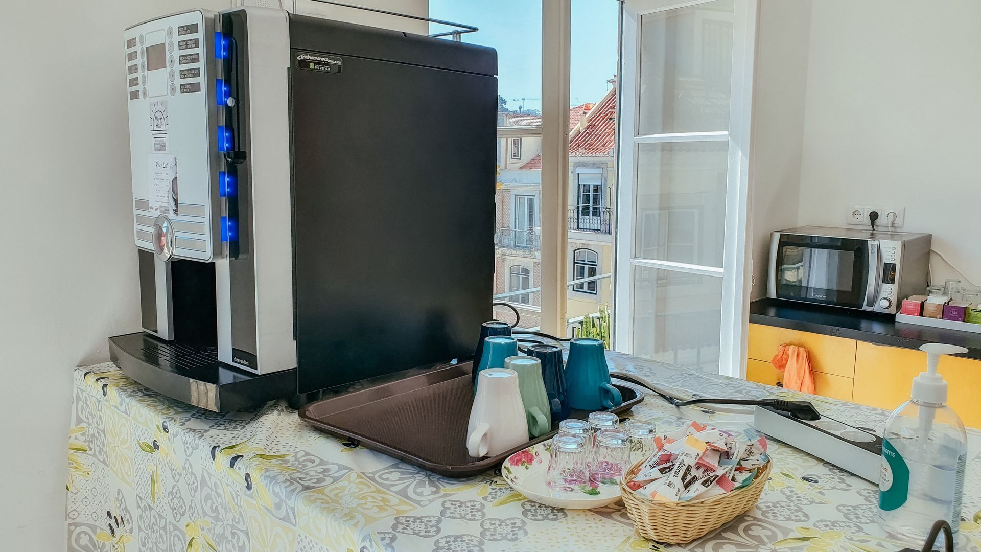 A coffee machine is sitting on top of a table next to a window.