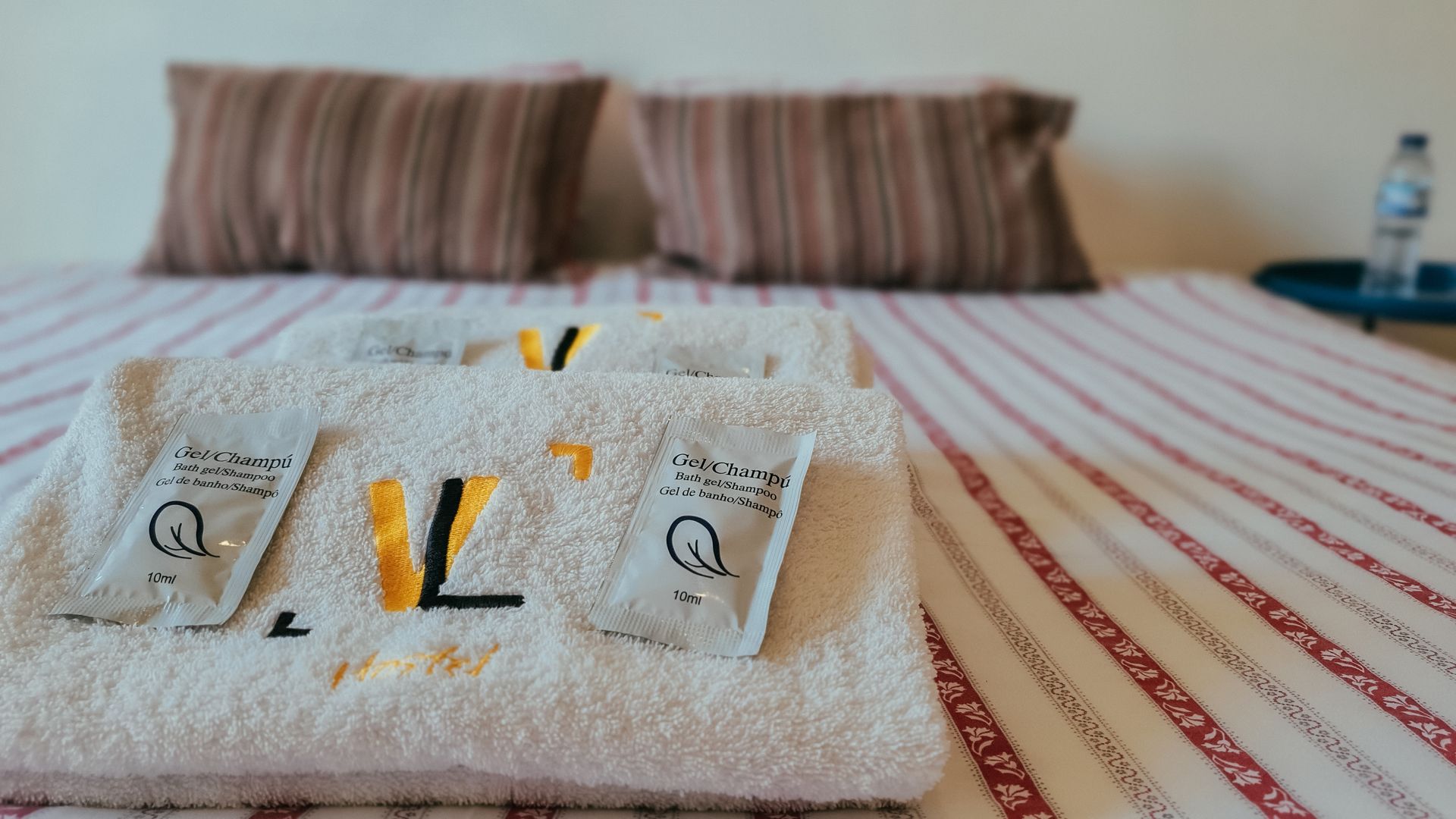 A bed with a stack of towels with the letter l on them