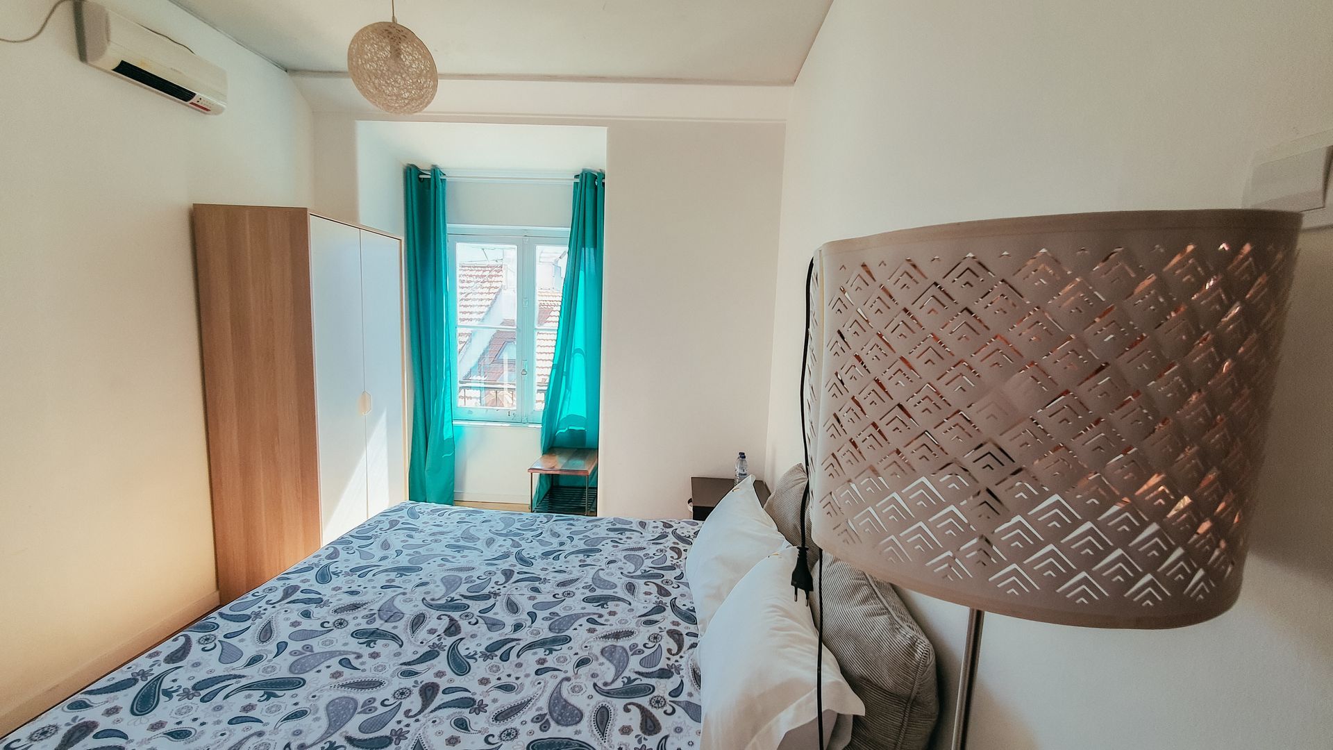 A bedroom with a bed and a lamp in it