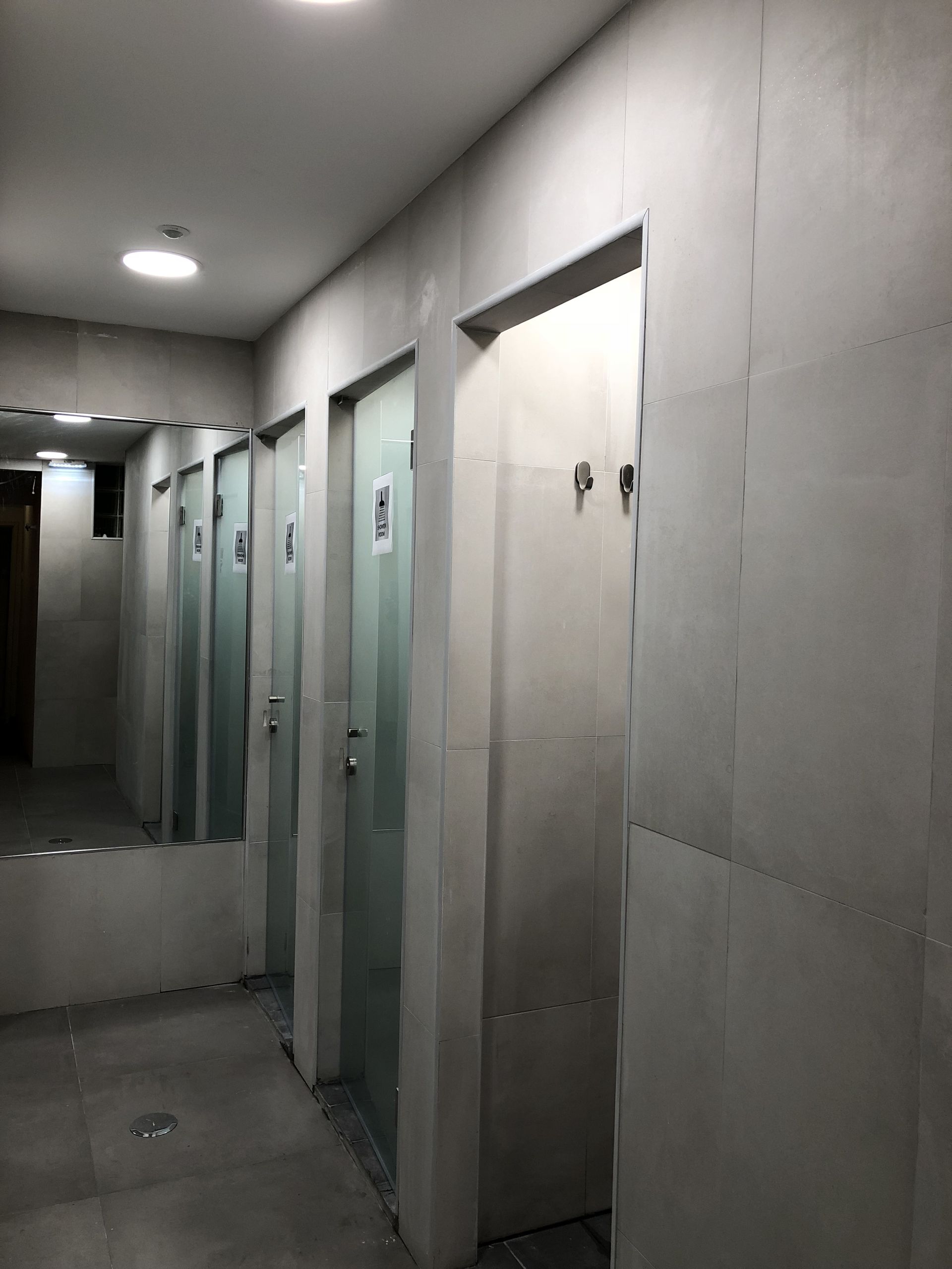 A hallway with a lot of doors and a mirror.