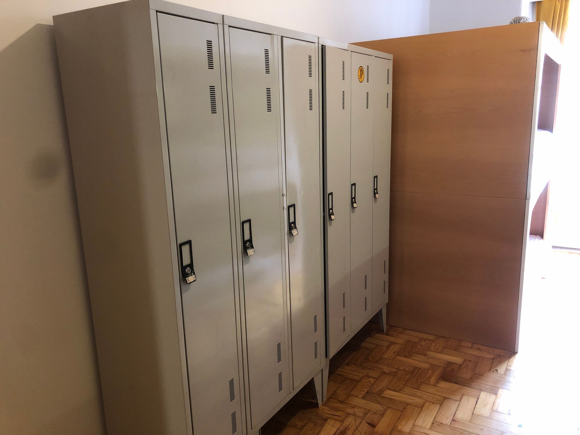A row of lockers in a room with a wooden floor