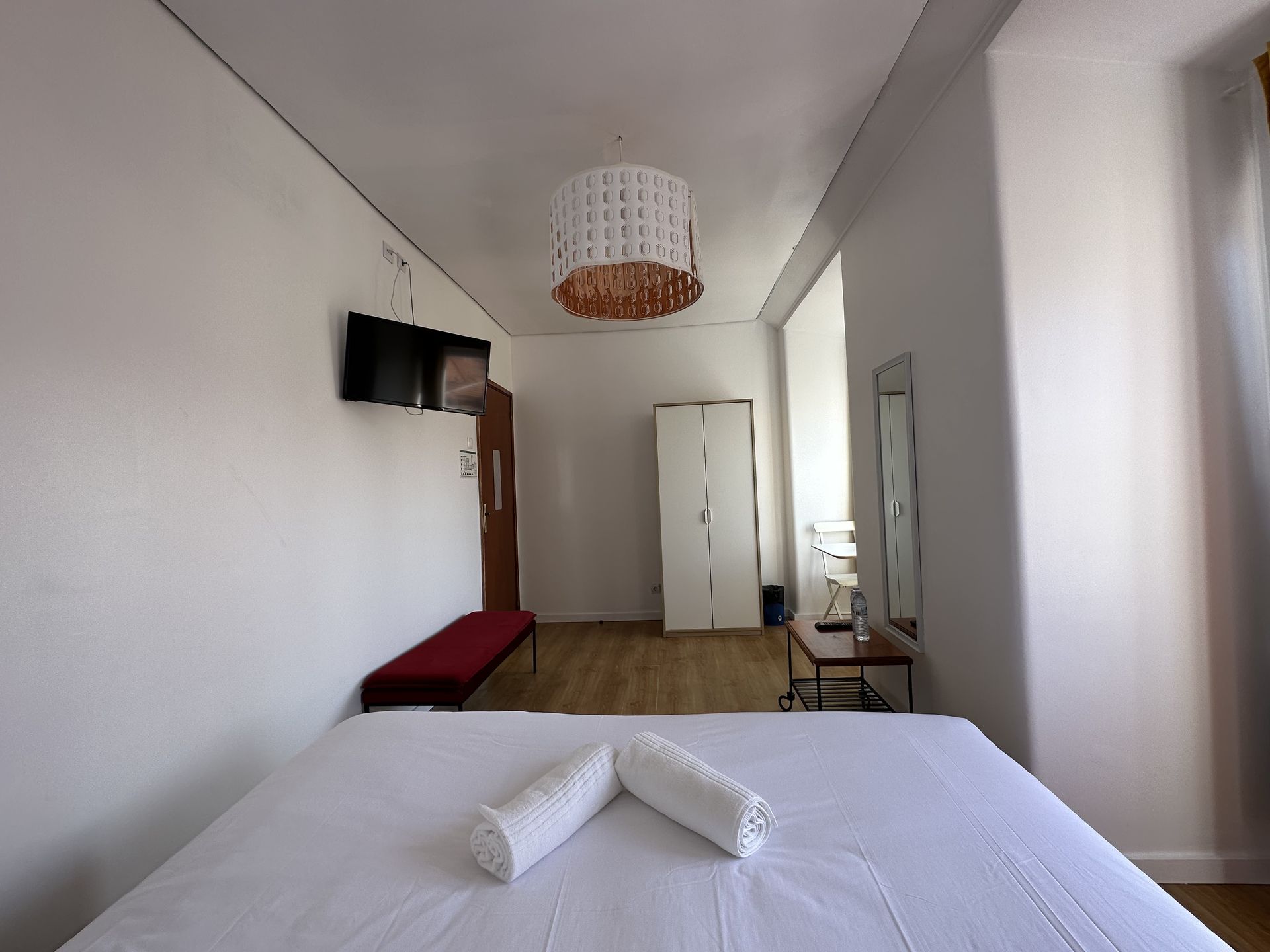 A bedroom with a large bed and a mirror