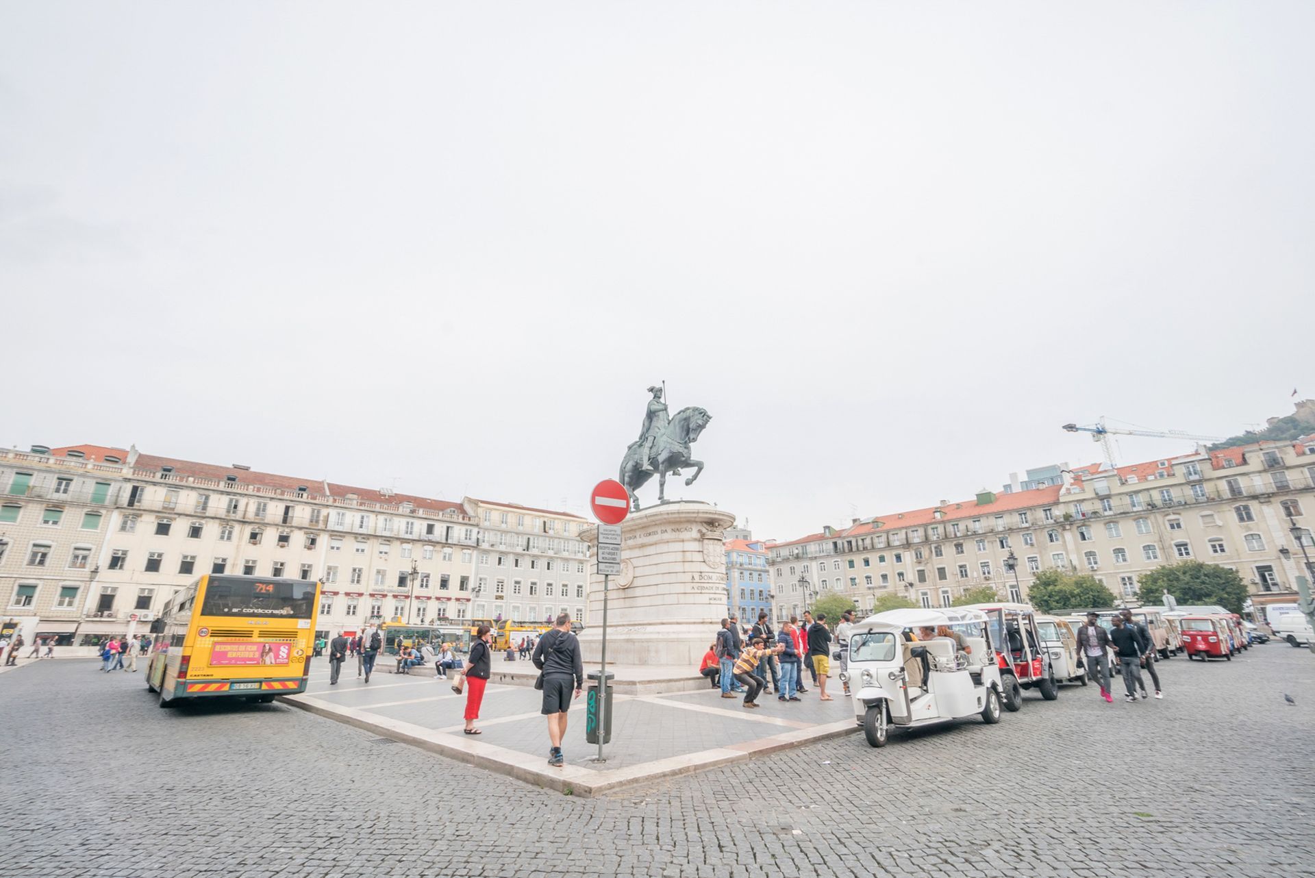 A statue of a man on a horse is in the middle of a city square.
