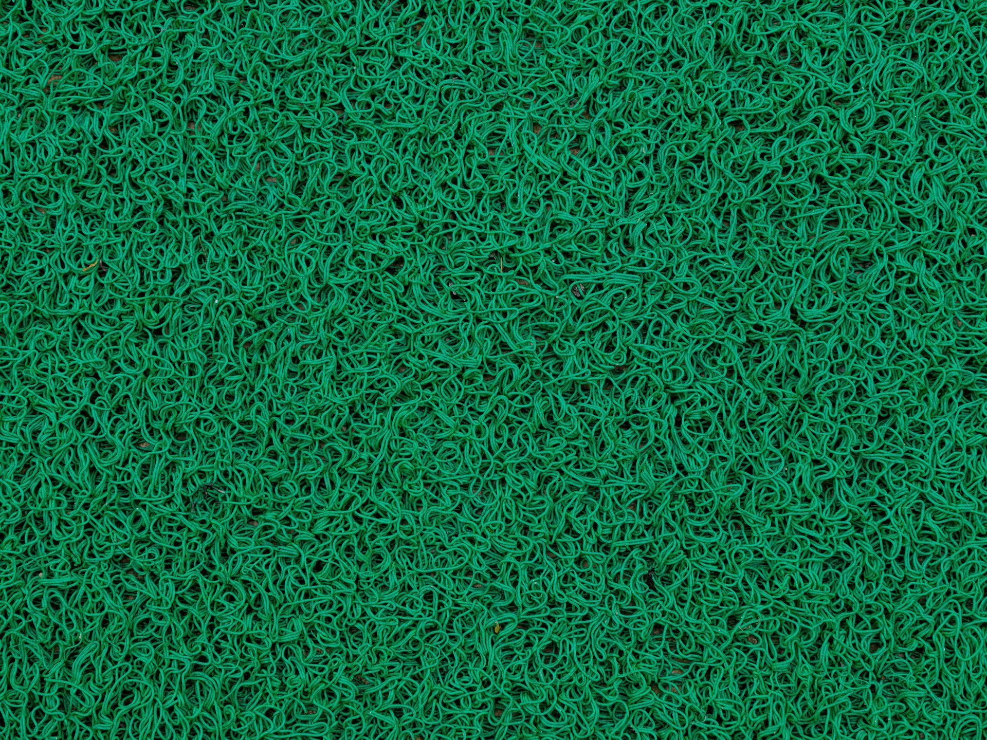 A construction worker is working on a machine on a brick sidewalk.