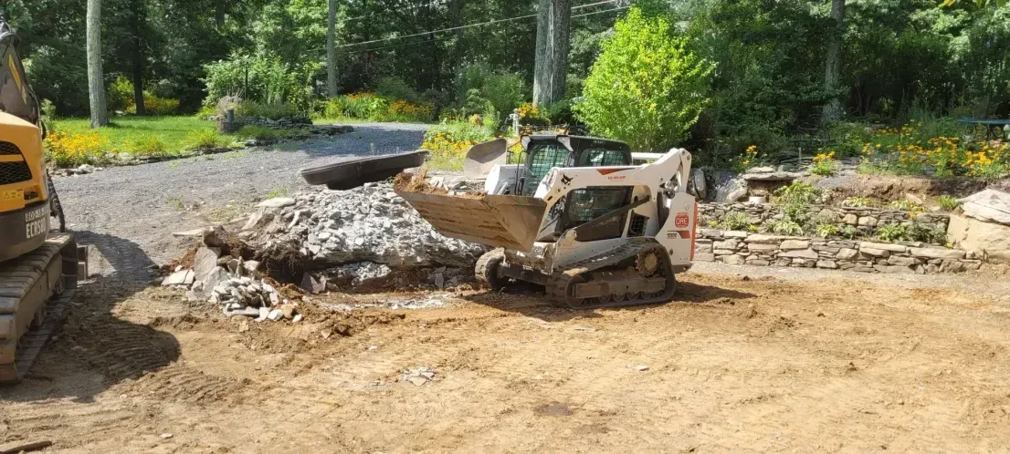 A bulldozer is sitting on top of a dirt field next to a pile of rocks.
