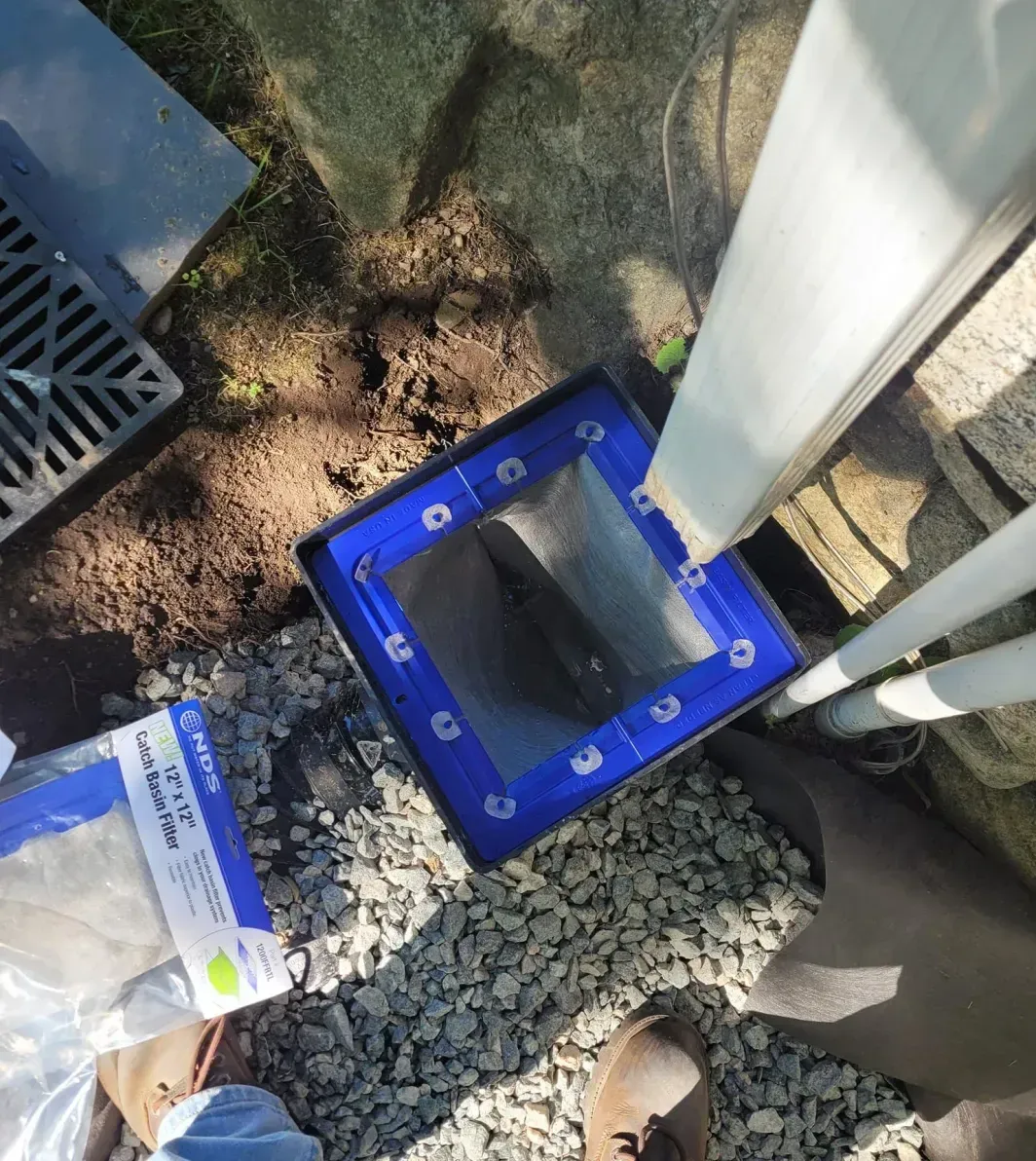 A person is standing next to a blue box with a hole in it.