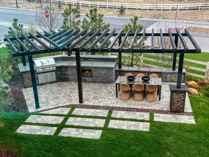 There is a table and chairs under a pergola in the backyard.