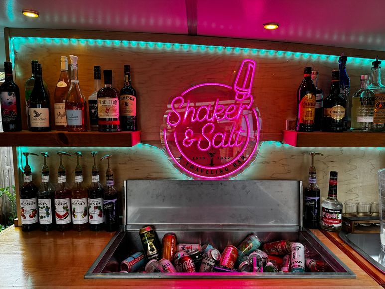 A bar with a neon sign that says shake & salt on it.