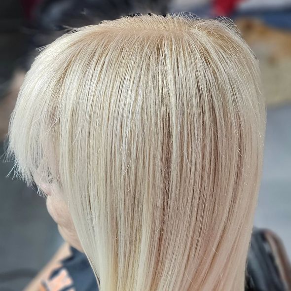 Cabello rubio con aspecto microtrenzado, inclinado hacia la derecha.