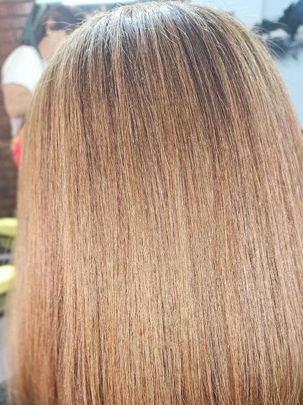 Cabello rubio y rizado, visto desde atrás, iluminado con luces y sombras variadas.