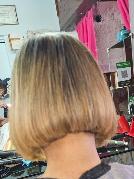 Corte bob rubio, vista posterior. Una persona en una peluquería, peinándose.