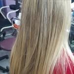 Cabello rubio en capas, peinado liso, con ligera variación de color.