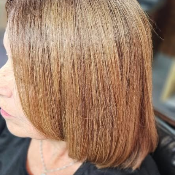 Mujer con cabello castaño claro hasta los hombros, corte bob en capas y en ángulo.