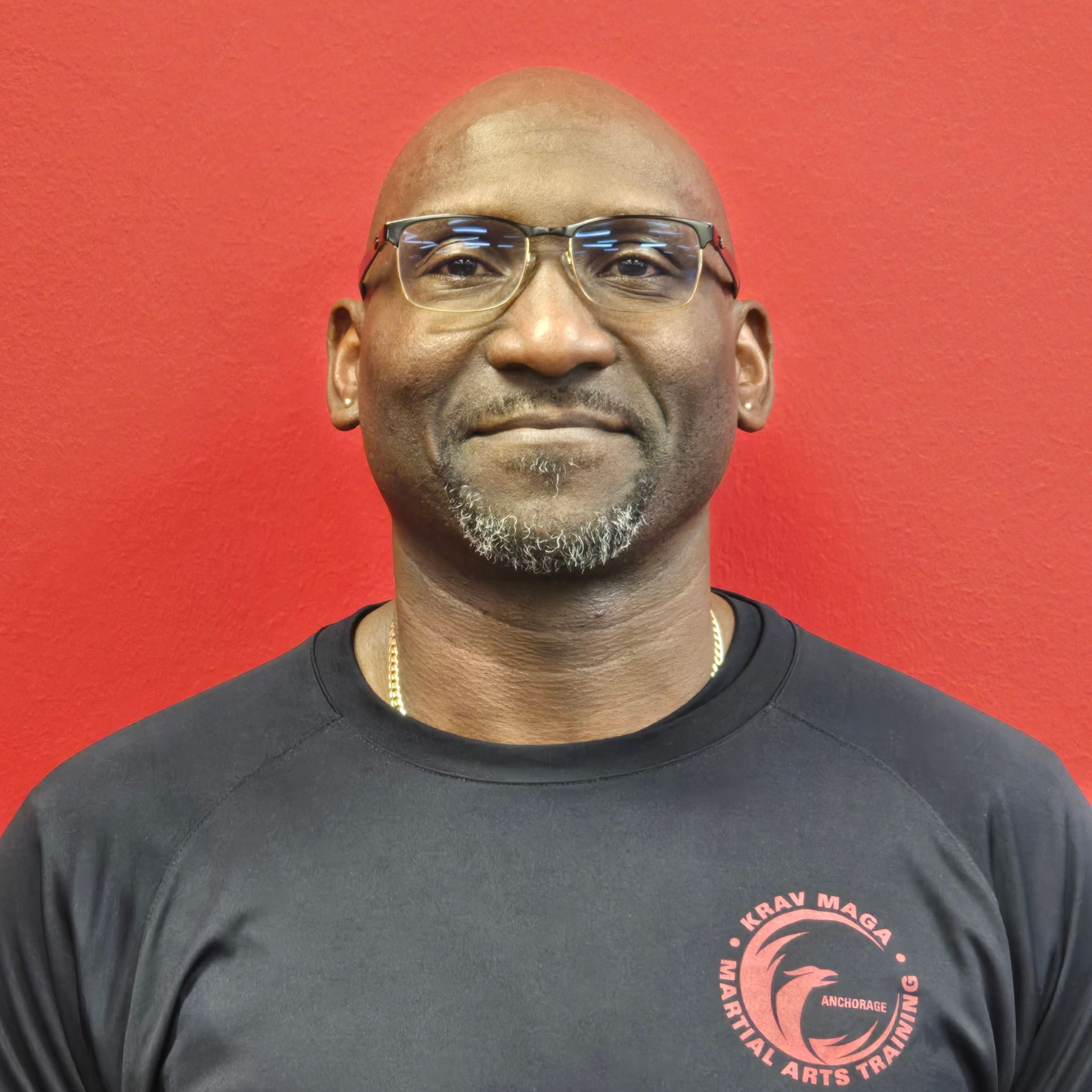 Man standing, smiling. Wearing a black top