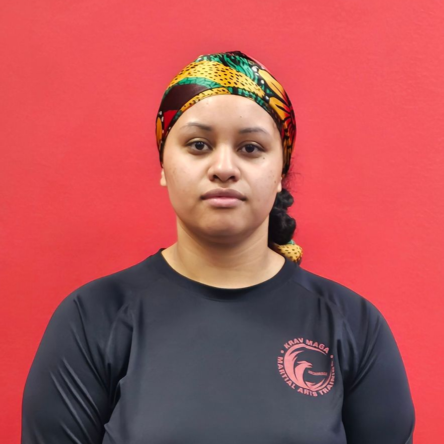 Woman standing, smiling. Wearing a black top