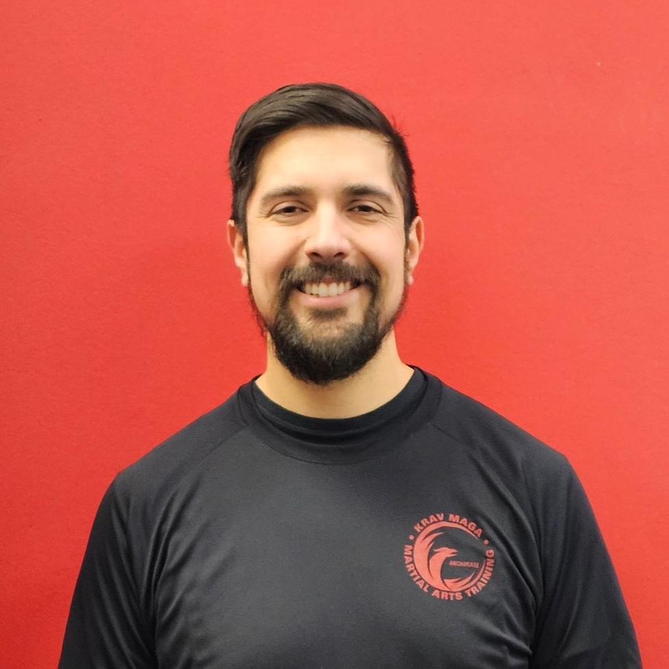 Man standing, smiling. Wearing a black top