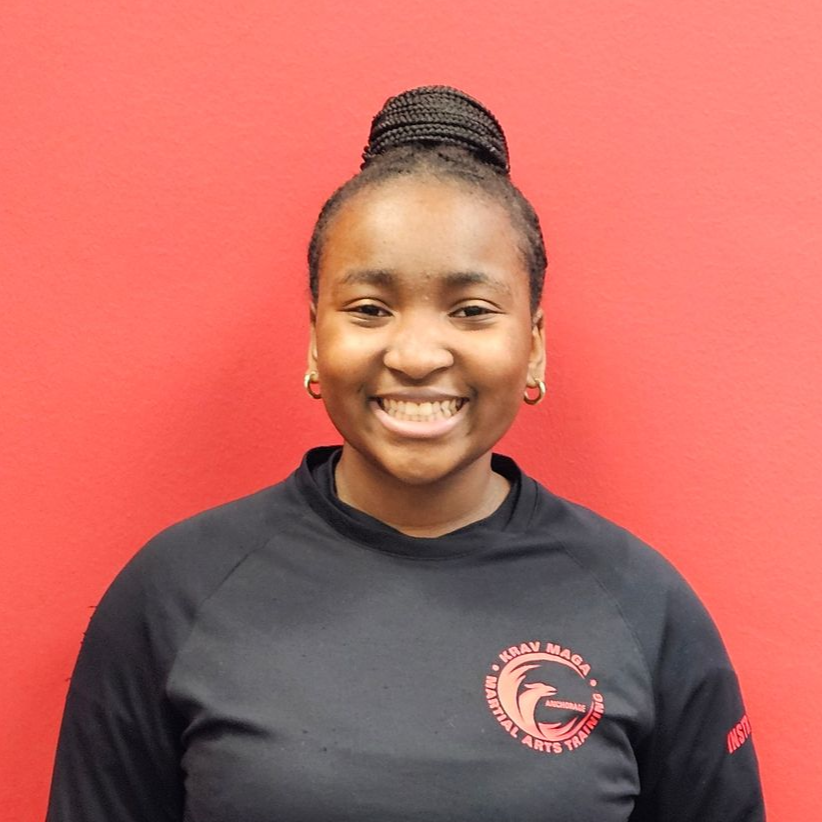 Girl standing, smiling. Wearing a black top
