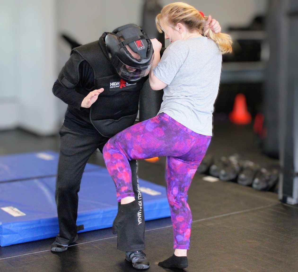 Woman kneeing attacker in our L.A.C.E. self defense course