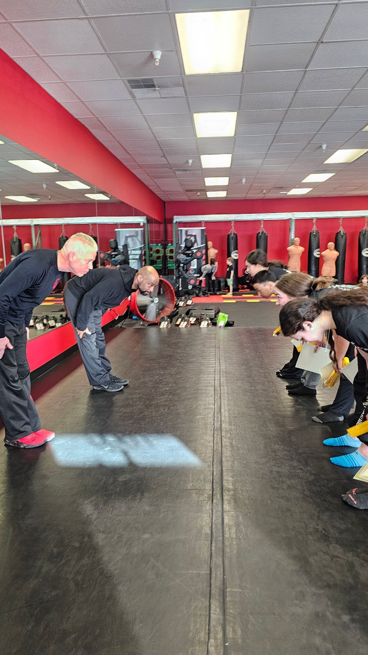 girls and boys bowing for passing their yellow belt in krav maga