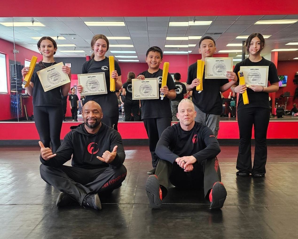 girls, boys and instructors smiling for passing yellow belt in krav maga
