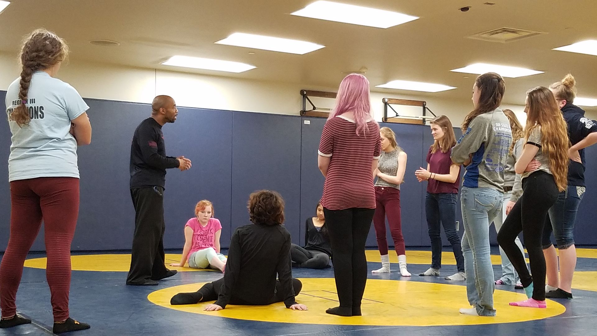 high school girls watching krav maga instructor
