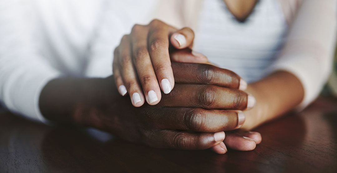 a woman is holding a man 's hand while sitting at a table .