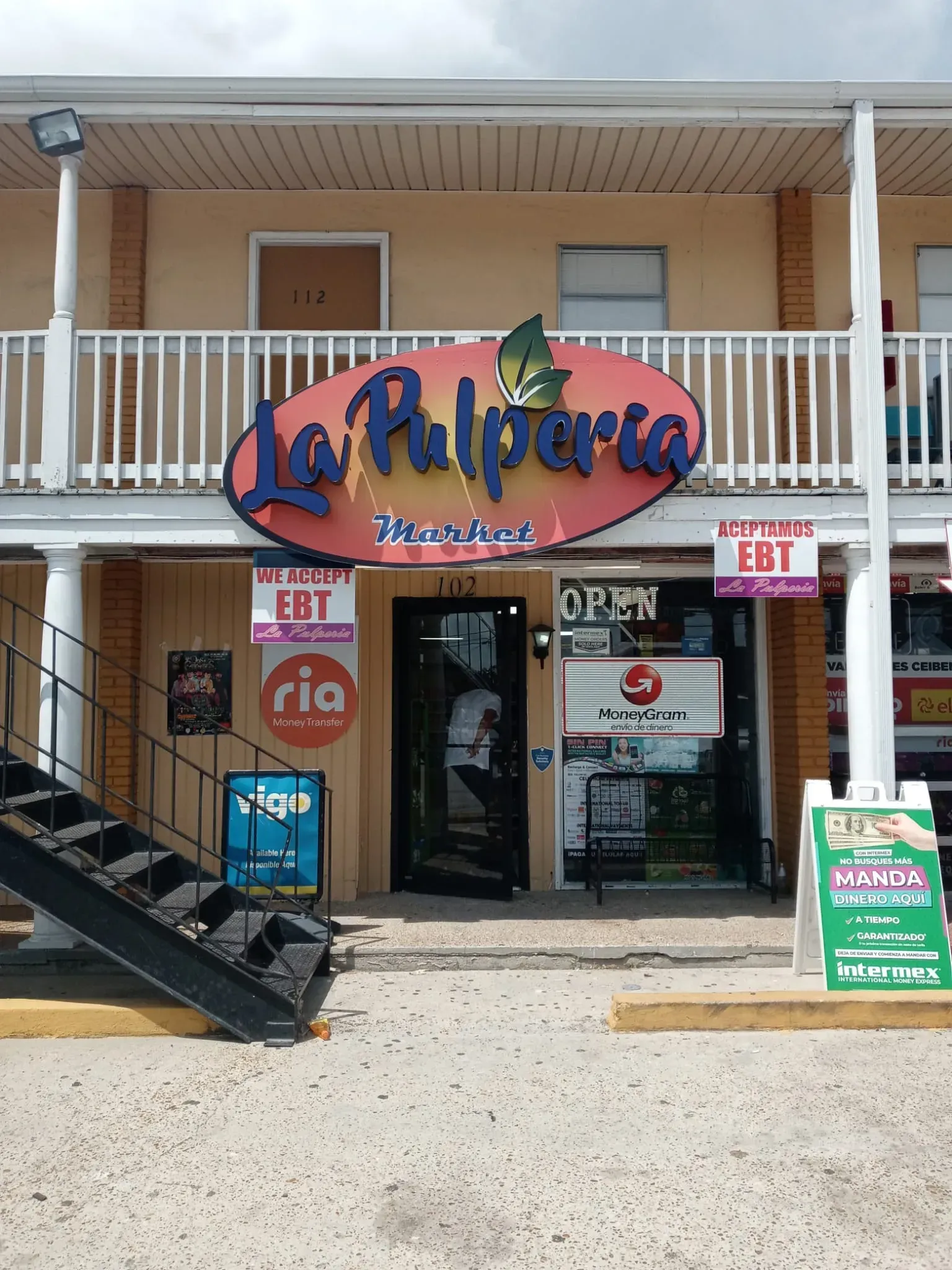 La Pulperia grocery store entrance. Red sign, black door, open sign. EBT accepted. Black metal stairs on left.