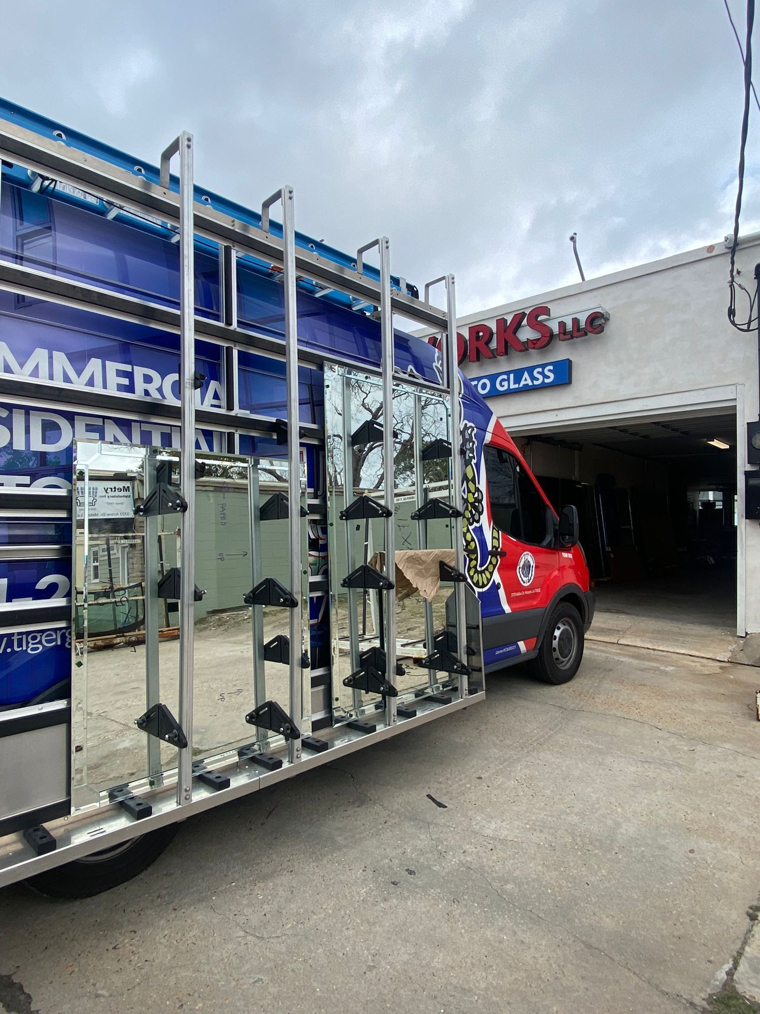 A glass delivery truck parked outside a business labeled