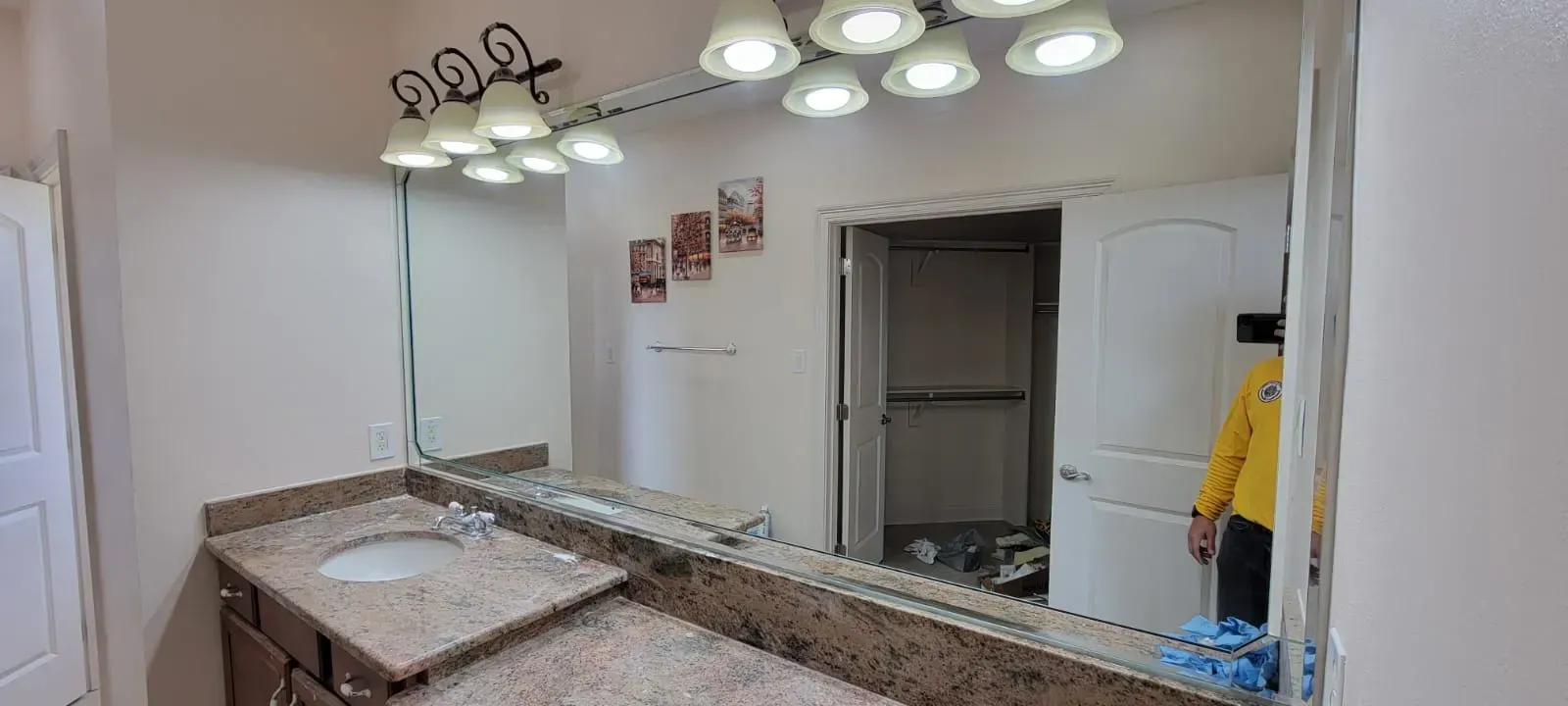 Bathroom with a large mirror, vanity, and overhead lights.  