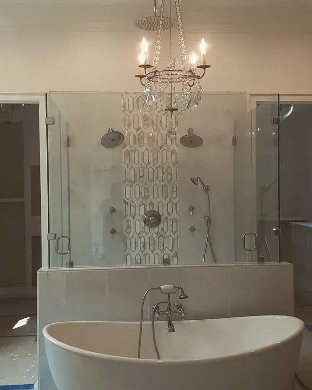 Luxurious bathroom with a chandelier, walk-in shower, and a freestanding bathtub.