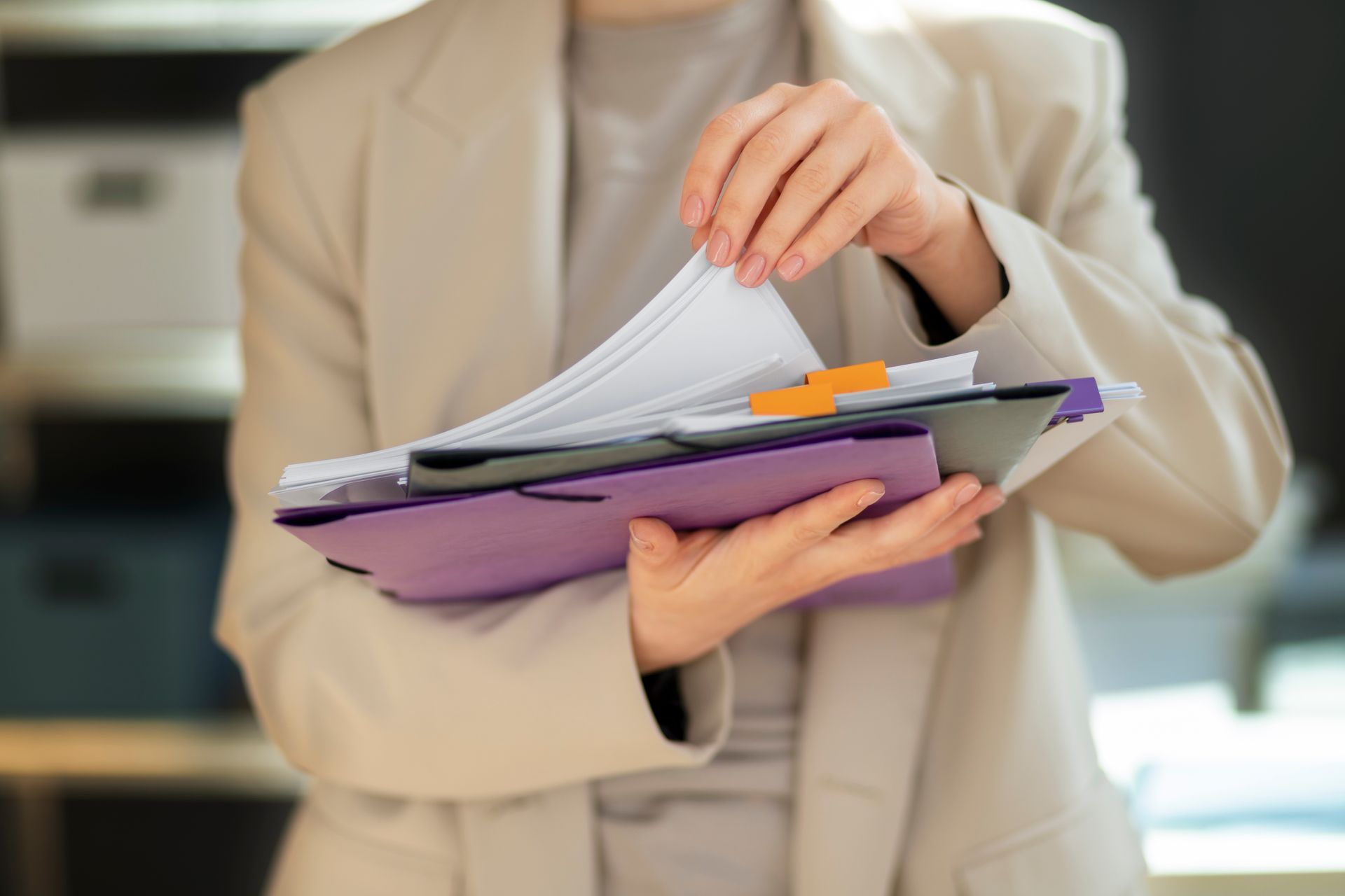 A woman is holding a stack of papers in her hands.