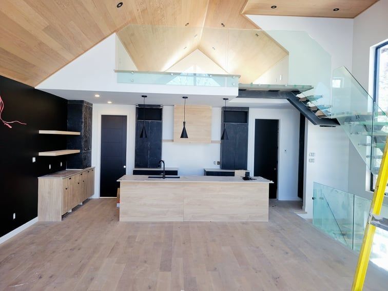 Une cuisine avec un îlot en bois et un escalier en verre